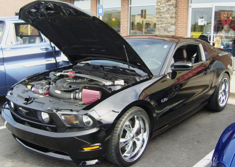 2007 Ford Mustang - A black Ford Mustang GT is parked with its hood open, revealing the engine and custom air intake system.