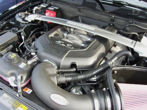2007 Ford Mustang - Engine bay of a Mustang GT showing the Coyote 5.0 32V Ti-VCT engine cover, a white-painted 'GT' strut tower brace, and an Airaid cold-air i…