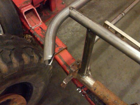 1995 Ford F-150 - Close-up of a custom buggy frame under construction, showing a large tire and welded metal tubing.