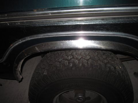 1979 Ford Bronco - Close-up view of the rear wheel well and tire on a 1979 Ford Bronco, chrome trim.