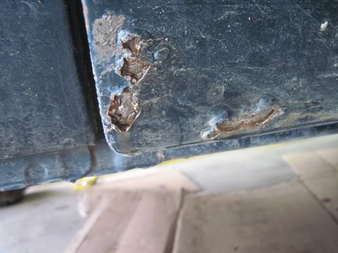 1979 Ford Bronco - Detail of significant rust and corrosion on a vehicle's lower body panel.