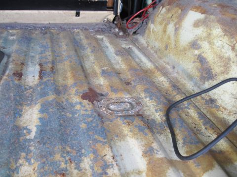 1979 Ford Bronco - The interior floor pan of a vehicle shows significant rust and wear.