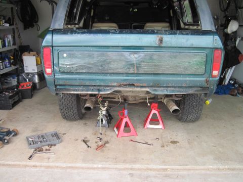 1979 Ford Bronco - Rear view of a green Ford Bronco undergoing maintenance in a garage.