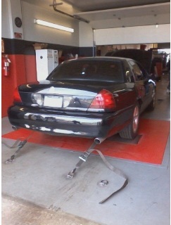 2004 Mercury Grand Marquis - A black 2004 Mercury Grand Marquis is positioned on a dynamometer in a garage setting.