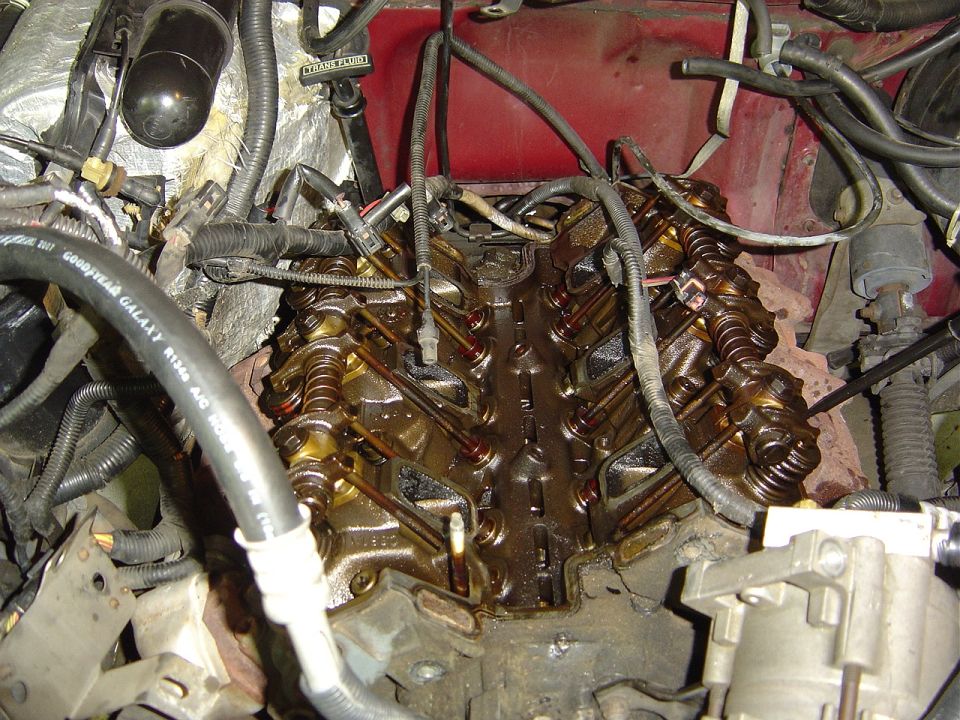 Close-up of an engine's valve train with oil visible