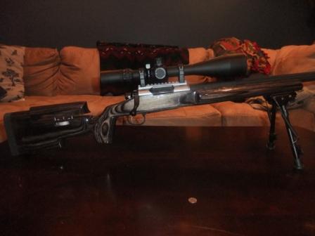 1996 Ford Bronco - Sniper rifle with scope and bipod is displayed on a table.