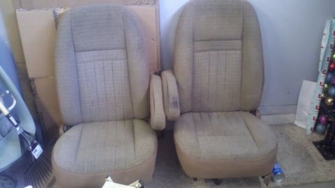1991 Ford Bronco - Two tan fabric car seats are shown side-by-side, with armrests on the inner sides.