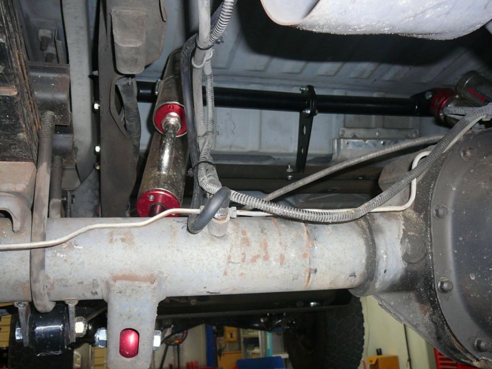 Undercarriage of a vehicle showing rear axle, shocks, and leaf springs