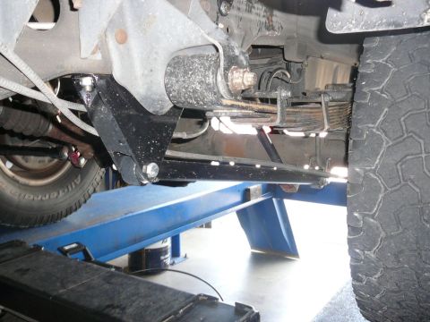 1988 Ford Bronco - Close-up view of a vehicle's suspension system and tire, likely undergoing maintenance or modification.