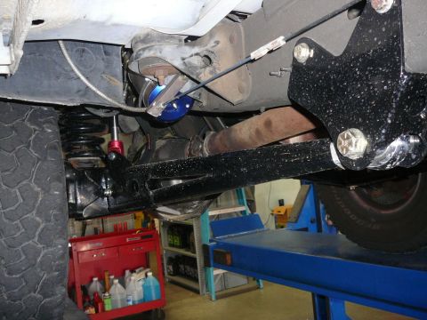 1988 Ford Bronco - Close-up of vehicle undercarriage, focusing on suspension and exhaust system components.