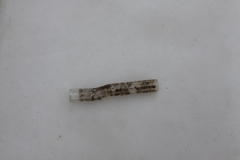 2003 Ford F-350 - Close-up of a clear plastic component with a textured surface, showing signs of wear and dirt.
