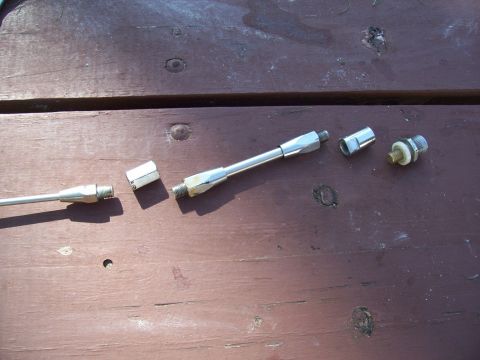 1978 Ford F-150 - Several metal rods and connectors are disassembled and placed on a wooden table.