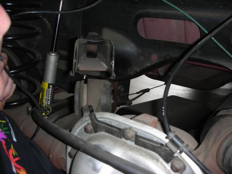 1998 Ford Crown Victoria - The photo shows a close-up view of the rear suspension system of a vehicle, focusing on the shock absorber and differential components.