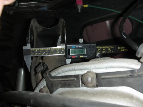 1998 Ford Crown Victoria - A digital caliper is used to measure a component of the vehicle's rear suspension system.