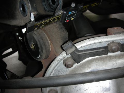 1998 Ford Crown Victoria - Measuring a suspension bushing with a digital caliper. The specific vehicle model is not identifiable.