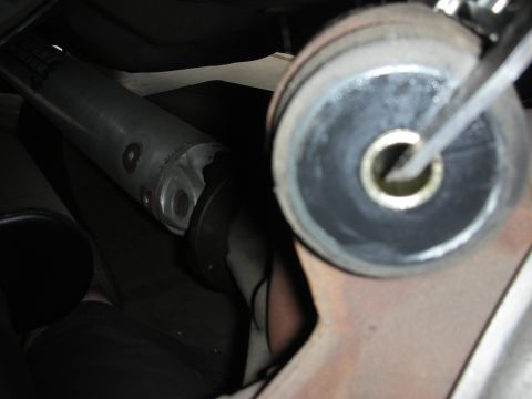 1998 Ford Crown Victoria - Underside view of a vehicle's driveshaft and suspension components, focusing on a rubber bushing.