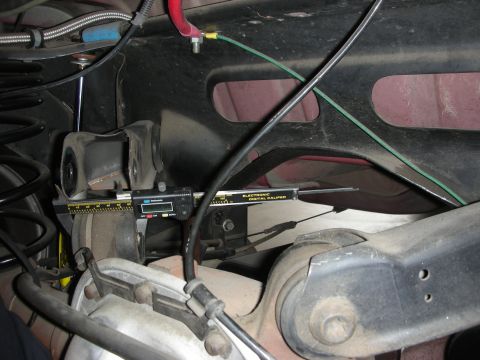 1998 Ford Crown Victoria - A digital caliper is used to measure a component of the rear suspension system.