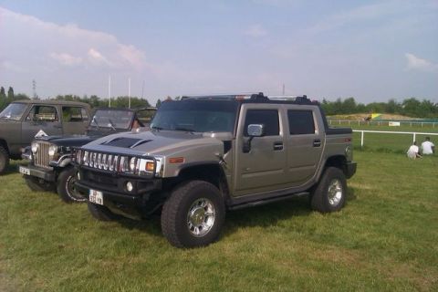 1991 Ford Crown Victoria - A tan Hummer H2 is parked on a grassy field next to other vehicles.
