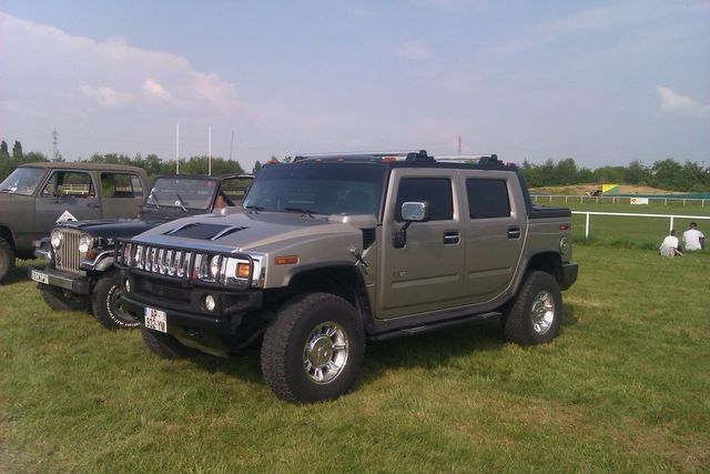 Tan Hummer H2 parked on grass with a license plate visible