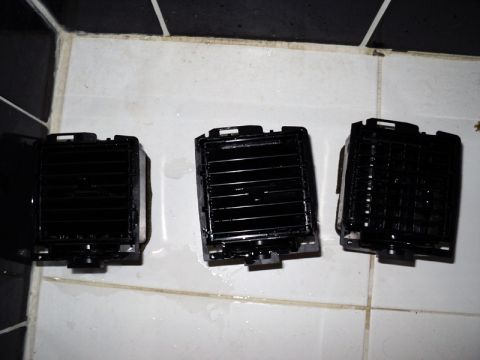 2001 Mercury Grand Marquis - Three car air vents are shown on a tiled surface, possibly after cleaning or replacement.