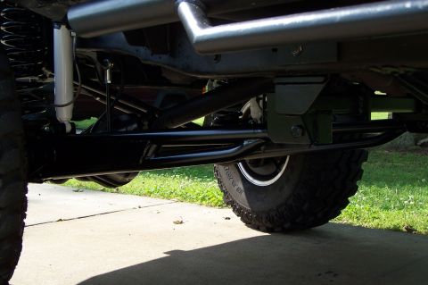 2000 Ford F-150 - The underside of a modified truck shows heavy-duty suspension components and large off-road tires.