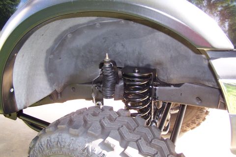 2000 Ford F-150 - The wheel well of a 2000 Ford F-150 shows a lifted suspension system and a large off-road tire.