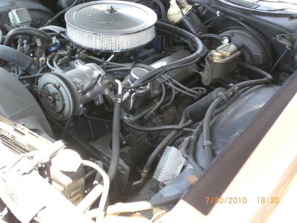 Engine bay showing V8 engine, air cleaner, and brake fluid reservoir