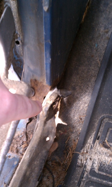 1979 Ford Bronco - Close-up of heavily rusted metal panel, showing damage and a finger pointing.