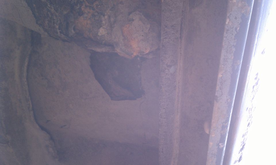 Close-up of heavily rusted metal frame, possibly from a vehicle undercarriage