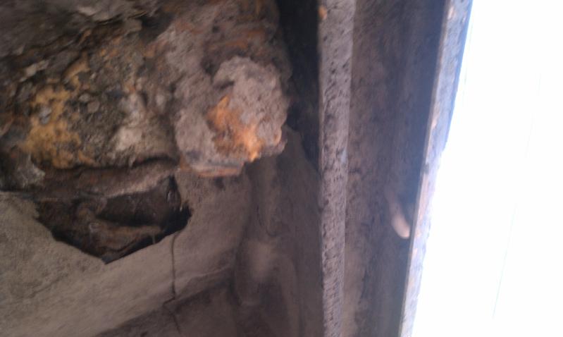 close-up of heavily rusted metal with a hole, showing decay