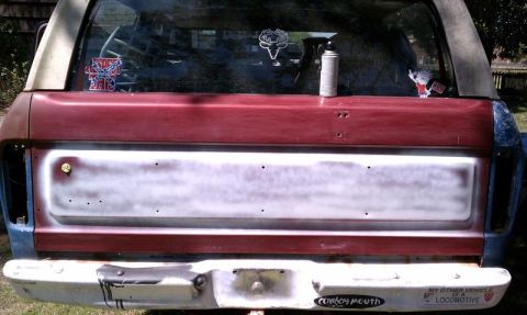 1979 Ford Bronco - This 1978 Ford Bronco's rear tailgate is covered in primer, with stickers and a spray can visible on the window.