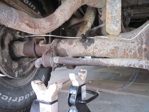 1979 Ford Bronco - The rear axle and suspension of a 1979 Ford Bronco are visible, supported by jack stands.