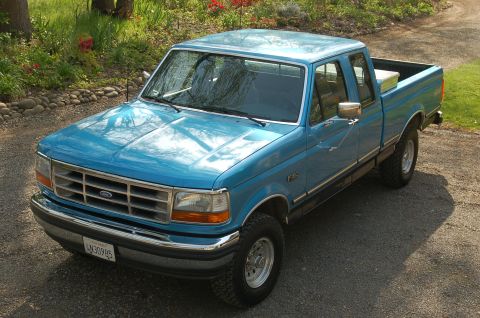 1992 Ford F-150 - A blue 1992 Ford F-150 pickup truck is shown from a high angle, parked outdoors.