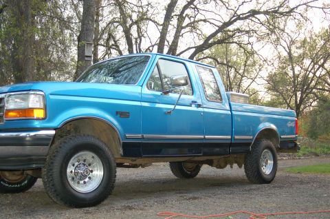 1992 Ford F-150 - This blue 1992 Ford F-150 pickup truck is shown from the side, a toolbox in the bed.
