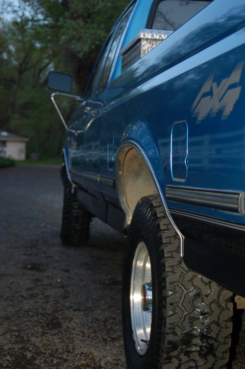 1992 Ford F-150 - This blue 1992 Ford F-150 pickup truck features a 4x4 decal on its side.