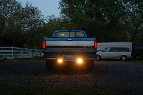1992 Ford F-150 - Rear view of a blue 1992 Ford F-150 pickup truck parked outdoors at dusk with other vehicles present.