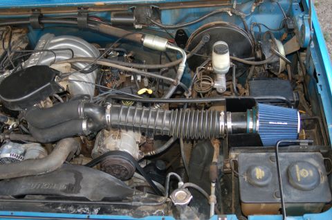 1992 Ford F-150 - Close-up view of a vehicle's engine bay, showing various mechanical parts and an aftermarket air intake system.
