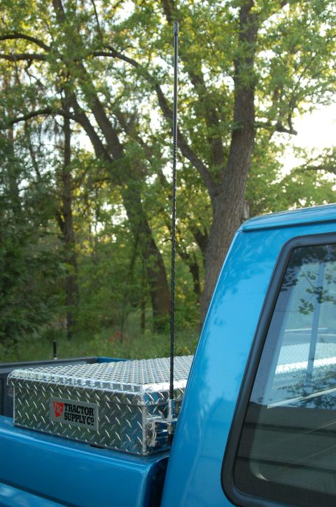 1992 Ford F-150 - A diamond plate toolbox and antenna are visible in the bed of a blue pickup truck.