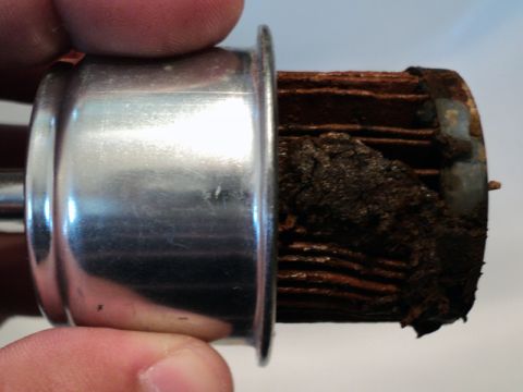 2001 Mercury Grand Marquis - This heavily clogged coolant filter shows significant buildup and rust within its media.