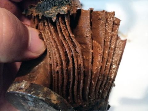 2001 Mercury Grand Marquis - A heavily clogged coolant filter shows the buildup of sludge and debris.