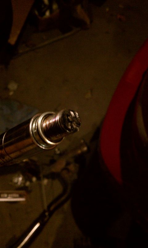 1999 Ford Expedition - A fouled spark plug shows significant carbon deposits on its electrode, indicating potential engine issues.