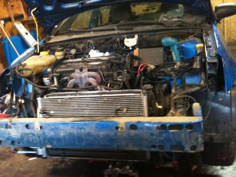 2002 Ford Focus - The engine bay of a blue car is shown with the front bumper removed, revealing the radiator and various engine parts.