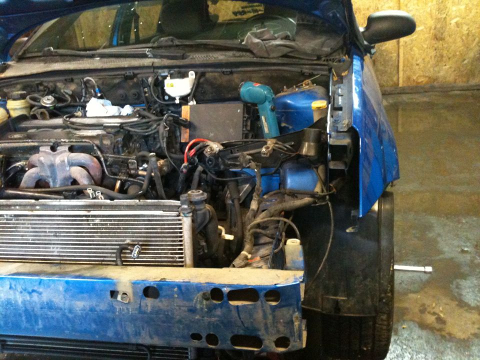 2002 Ford Focus engine bay with front bumper removed, showing radiator and engine components