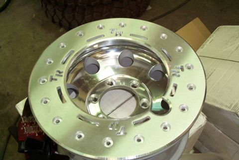 1988 Ford Bronco - Close-up of a polished aluminum wheel, a prominent 'TR' logo and numerous bolt holes.