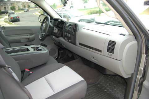 2007 Chevrolet Silverado 1500 - The interior of a truck shows the dashboard, center console with cup holders, and front seats.