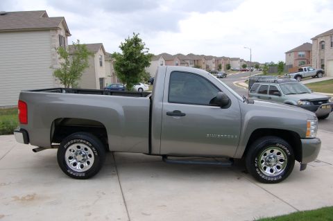 2007 Chevrolet Silverado 1500 - A silver Chevrolet Silverado pickup truck is parked on a suburban driveway.