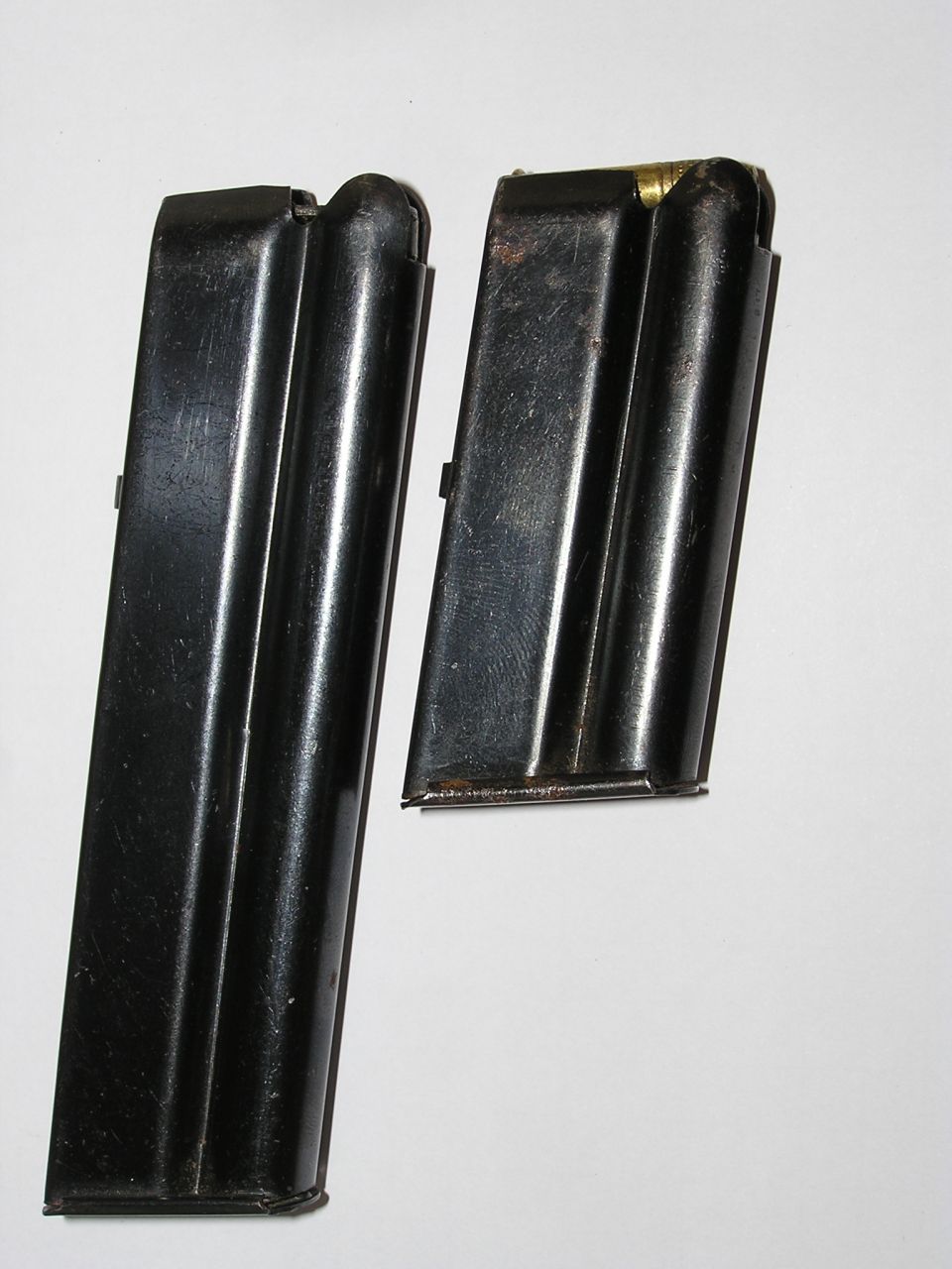 Two blued steel .22 rifle magazines standing upright on a plain white background