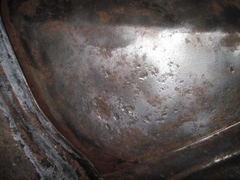 1979 Ford Bronco - This image shows a heavily rusted metal surface, likely part of a vehicle's underbody or frame.