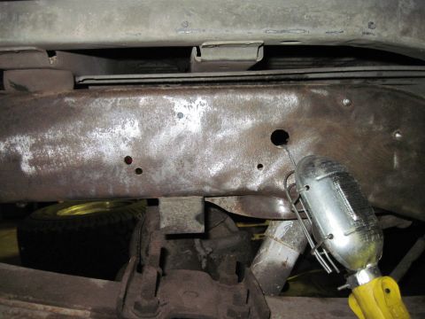 1979 Ford Bronco - Underside view of a vehicle's frame, showing rust and a spare tire.
