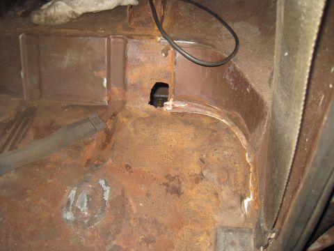 1979 Ford Bronco - Interior floor pan shows significant rust damage and a hole.